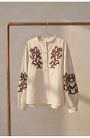 Alma embroidered linen blouse on hanger
